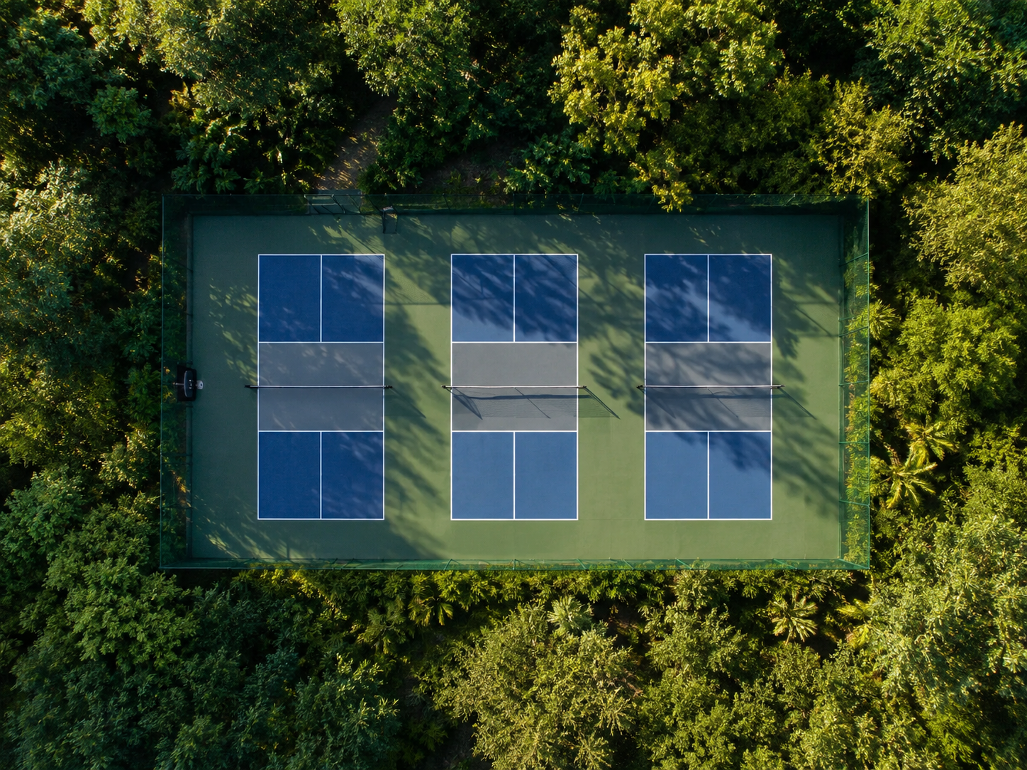 Players competing in a pickleball doubles match on an outdoor court